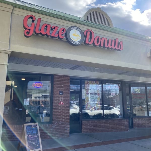 The storefront of Glaze Artisan Donuts and Coffee, with an "OPEN" sign in the window.
